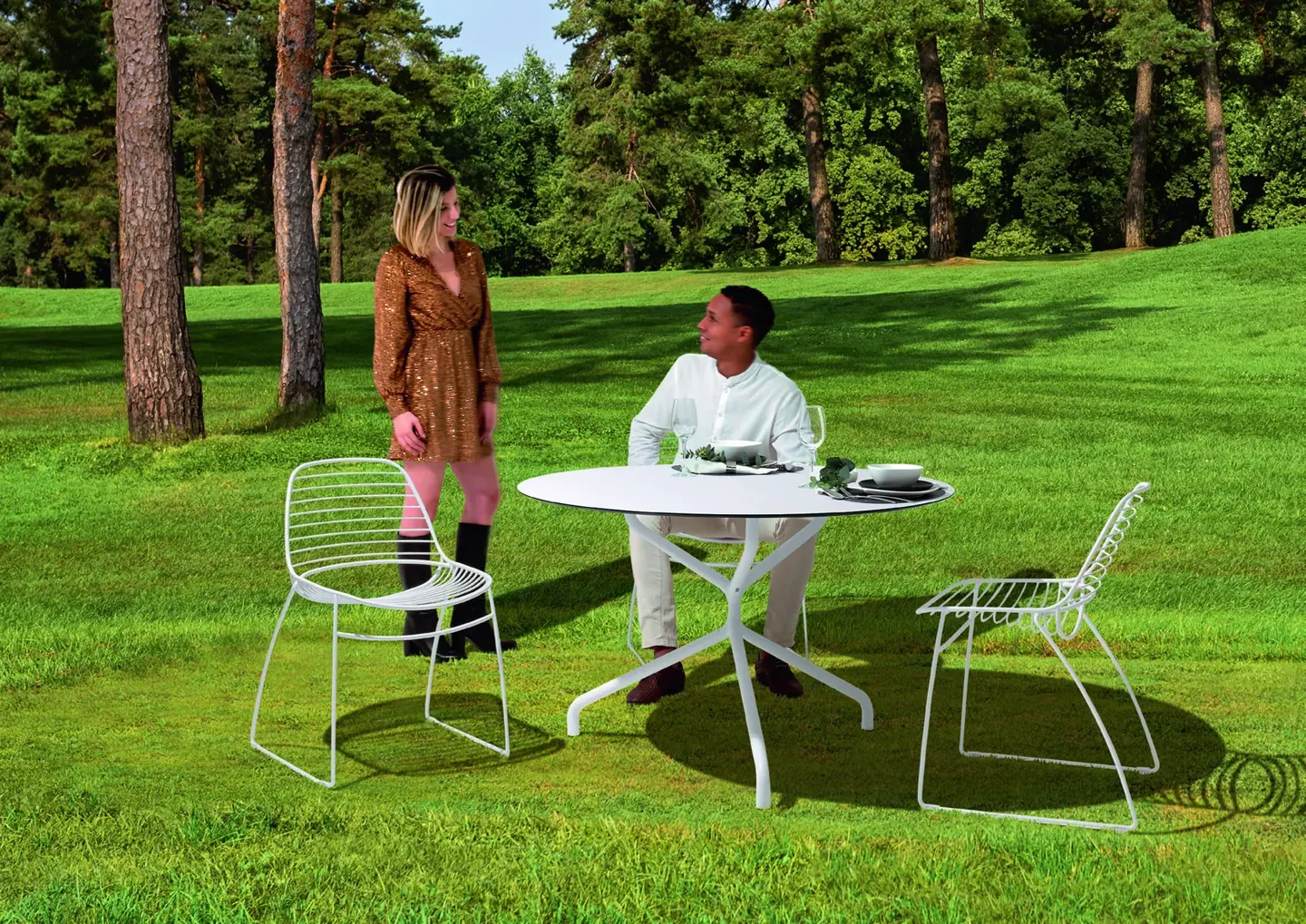 Eclipse Wire chairs around a round outdoor table in a garden