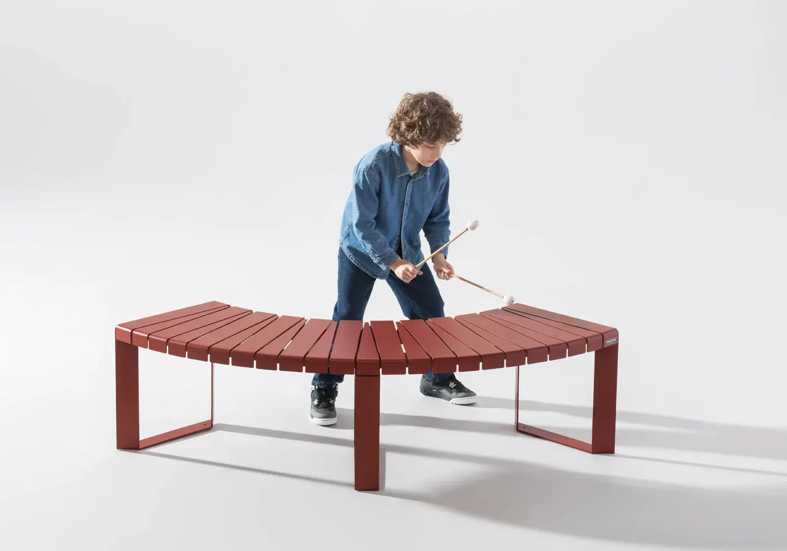 Red curved Liberty.080 bench with a child playing