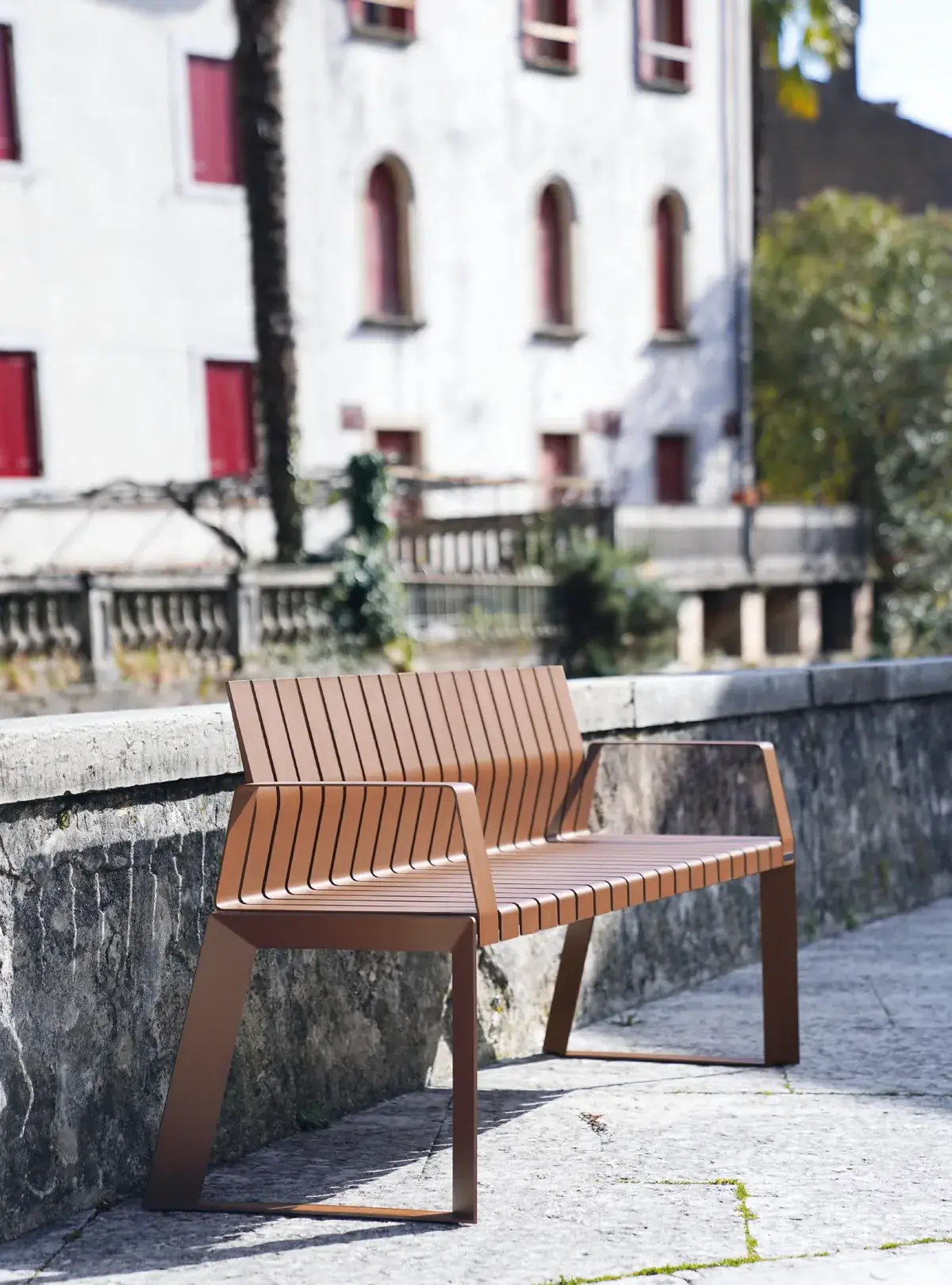 Brown Liberty.080 bench installed along a street wall